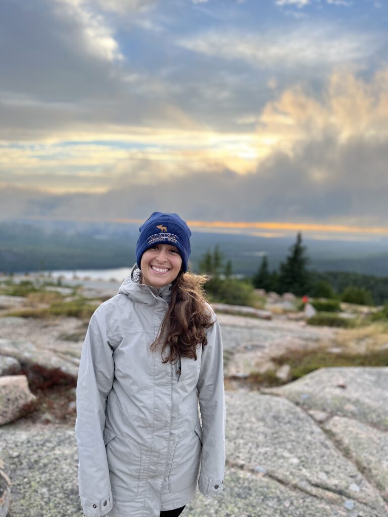 Lindsay (author) standing on Cadillac Mountain during sunset. 