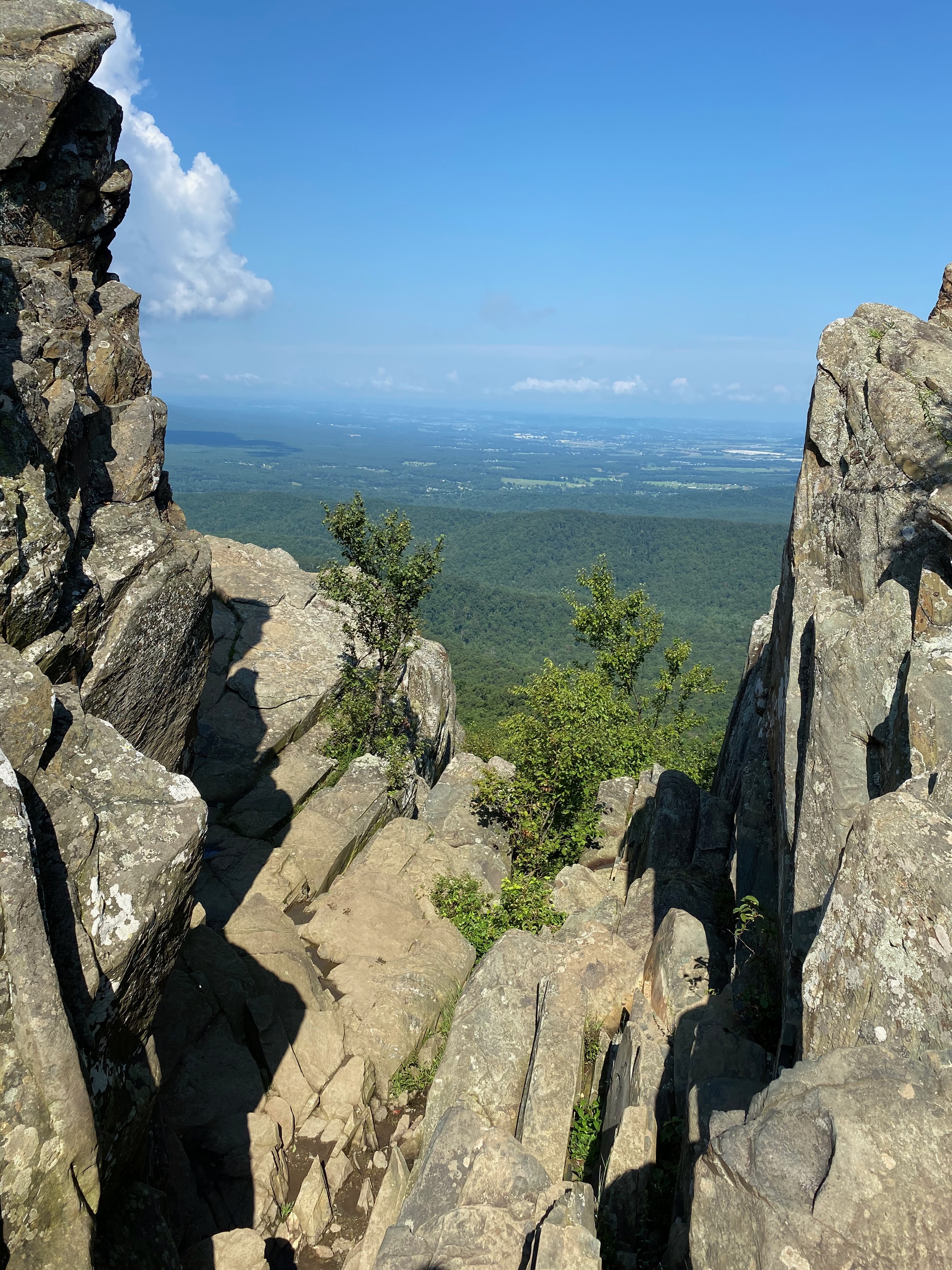 Scenic view of a jagged rocky mountain top with the shenandoah valley in the background and a blue sky overhead.