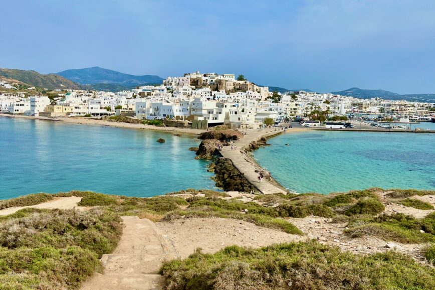 View of Chora town in Naxos with all the whitewashed buildings in the background with the light blue aegean sea surround it.