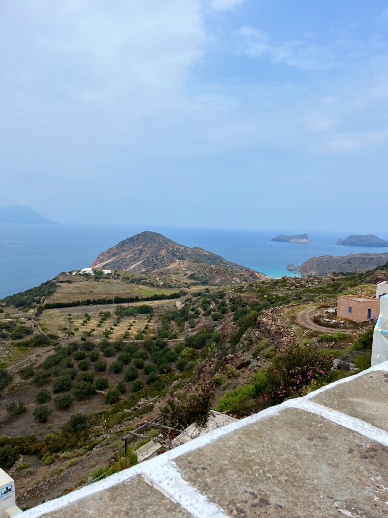 Spectacular panoramic view of the azure Aegean Sea and picturesque islands from Plaka in Milos, Greece, capturing the serene beauty of the Mediterranean coastline.